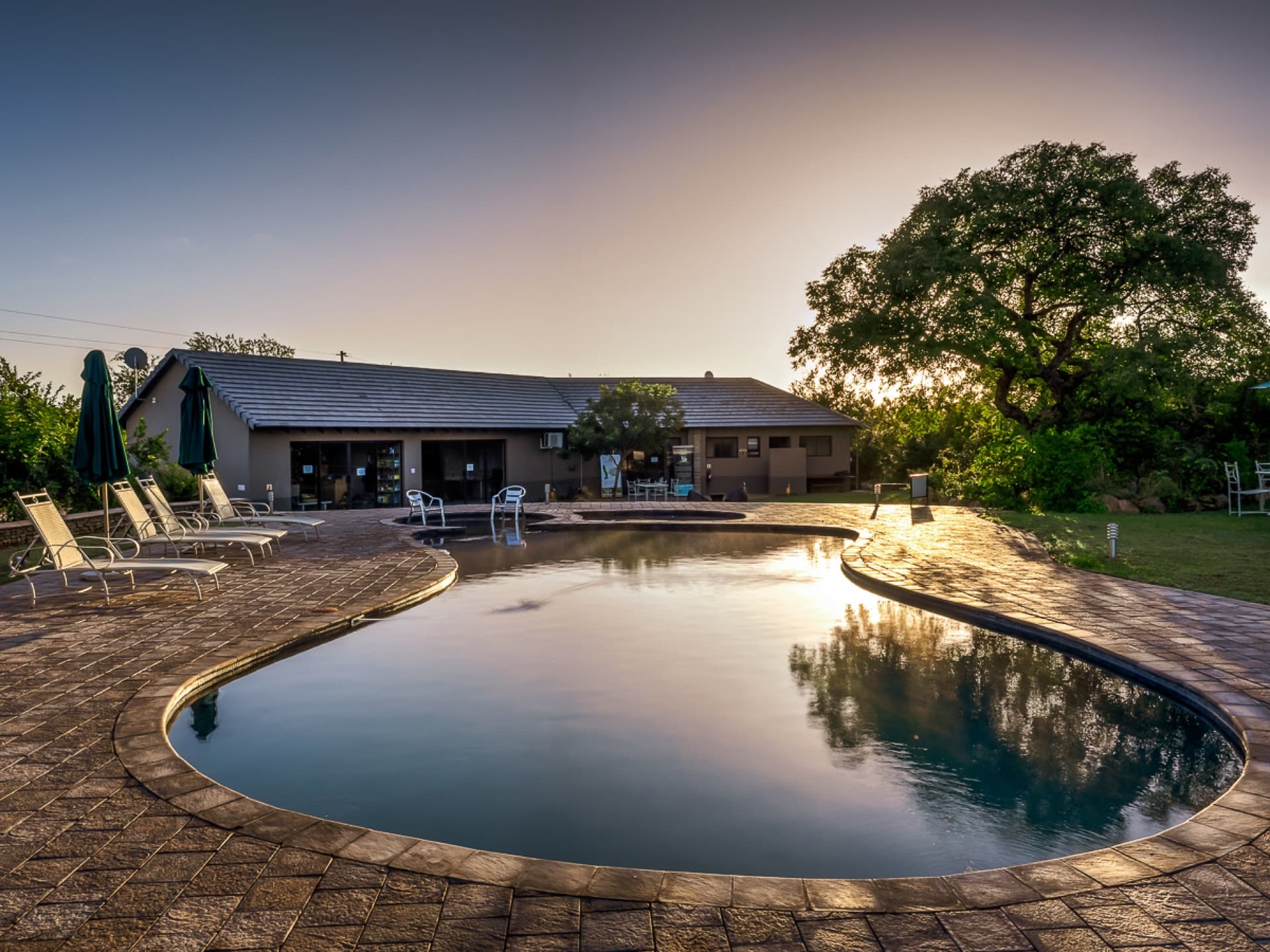 Mjejane Bush Camp pool area at sunset with sun loungers