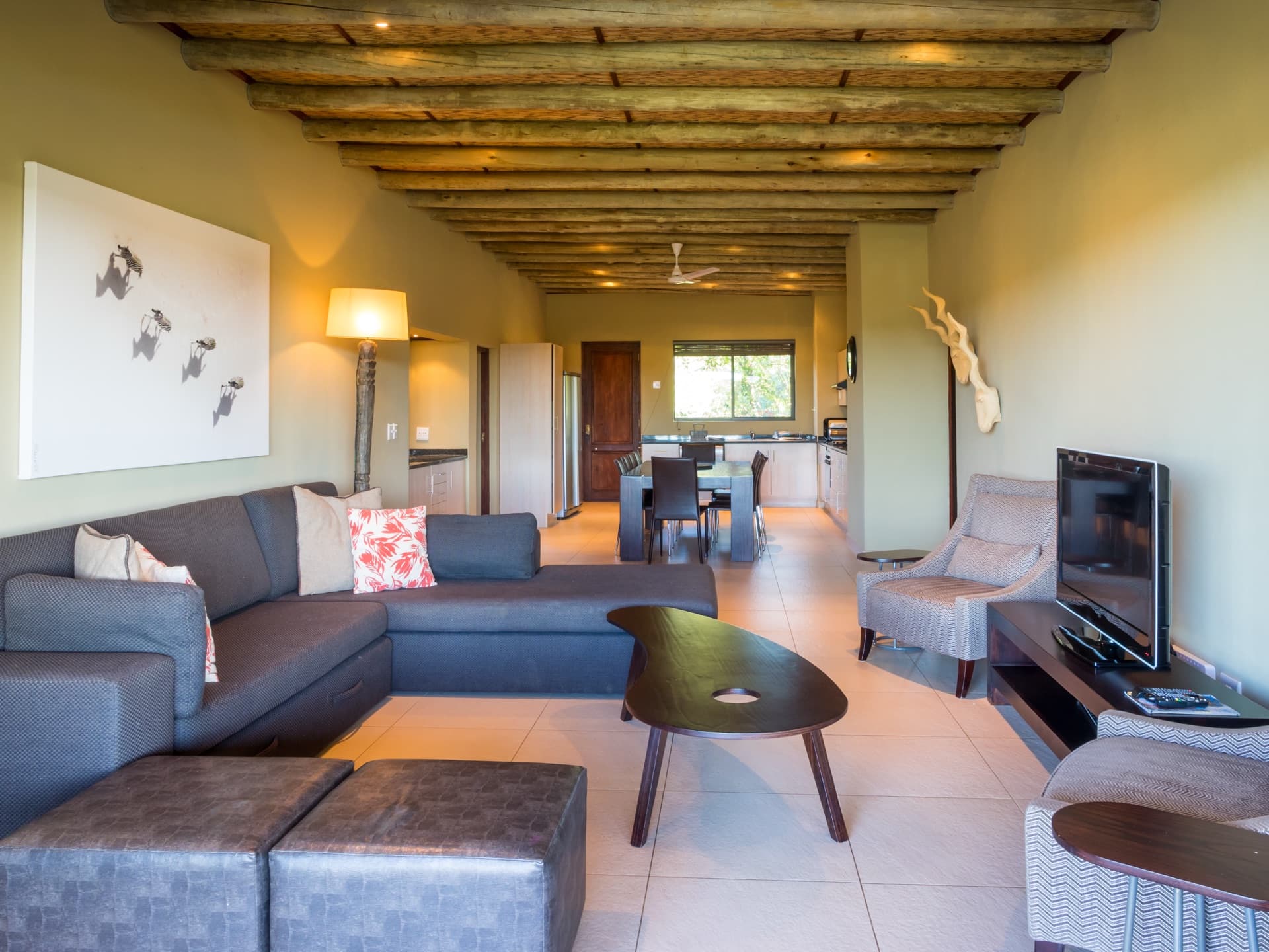 River unit open-plan lounge with sectional sofa and bush art