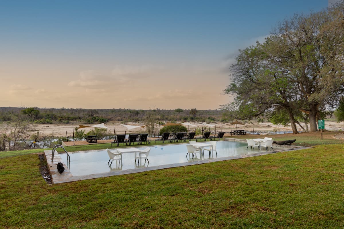 Pool and terrace at Mjejane River Lodge overlooking the Crocodile River at golden hour